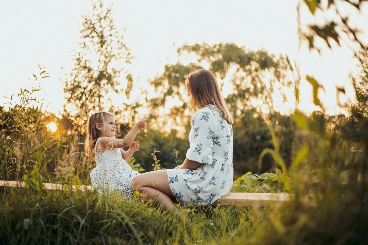 An adult and a child sitting together in the evening sunlight, Inner Child Workshops New Day Therapies Hull
